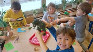 dzieci  bawią się figurkami dinozaurów