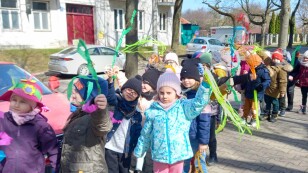 Dzieci z gaikami i wstążkami witają na spacerze wiosnę