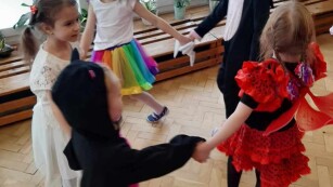 bal karnawałowy dzieci tańczą w kółko w przebraniach