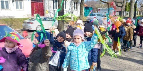 Dzieci z gaikami i wstążkami witają na spacerze wiosnę